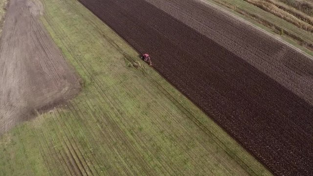 Plowing of pepper field on cloudy fall day. Aerial footage.