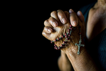 Close up of old hands praying on black background, Concept hope and worship