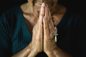Close up of old hands praying on black background, Concept hope and worship
