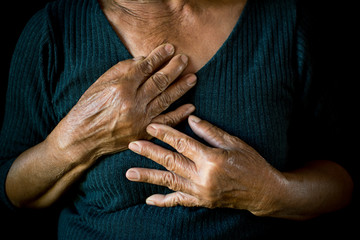Old woman felt heart ache on black background,Illness of the elderly problem concept