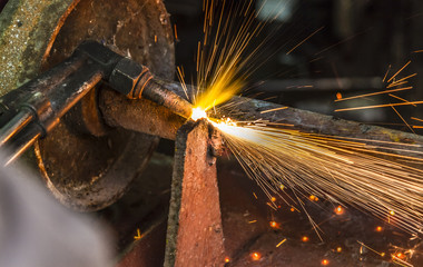 the worker cutting steel with an industrial cutter.