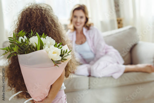 little daughter with bouquet of flowers for her mom on happy mothers day