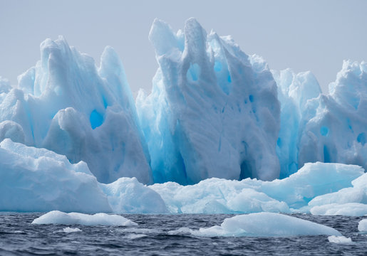 Blue iceberg floating in Esperanza in Antarctica with fissures, crevices and cavities.
