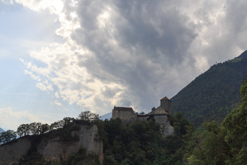 Fototapeta na wymiar Tyrol Castle, dark storm clouds and mountain panorama in Tirol, South Tyrol