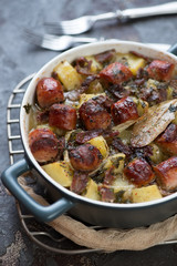 Bowl of Dublin coddle or Irish dish of sausages, bacon, onions and potatoes, close-up, selective focus