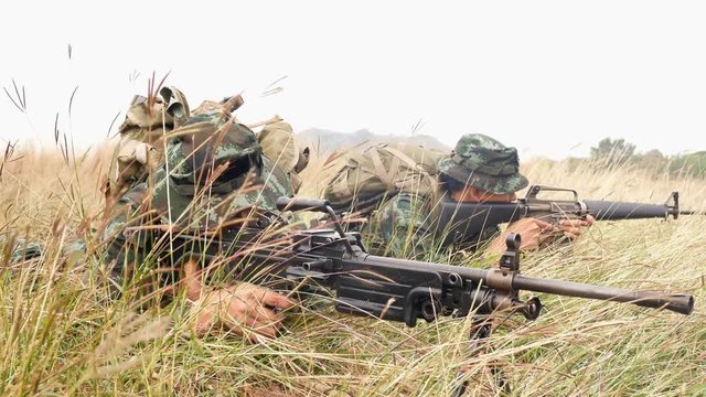 Soldiers team holding gun prepare to attack enemy at fields. 