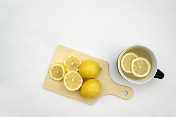 Hot lemon tea and lemons isolated on a white background.