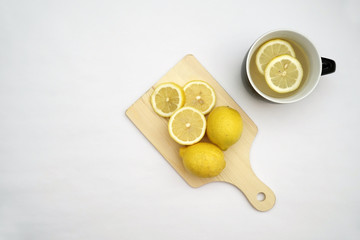 Hot lemon tea and lemons isolated on a white background.