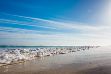 Fototapeta na wymiar Calm sea and surf on a sandy beach. summer sea in Sunny weather with blue sky. Beautiful sandy beach and transparent waves