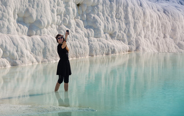 Woman walking on the terraces at Pamukkale. It cotton castle in Turkish and is natural site