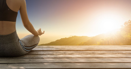 Asia young woman practicing yoga in nature at sunset