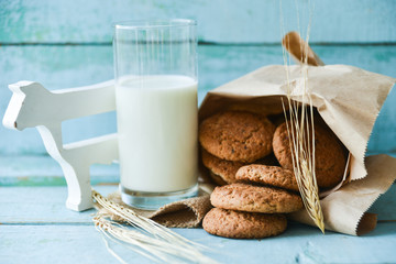 fresh oatmeal cookies with milk on wooden background