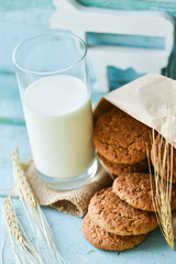 fresh oatmeal cookies with milk on wooden background