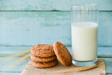 fresh oatmeal cookies with milk on wooden background