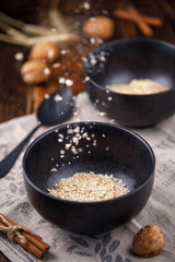 Breakfast. Oatmeal flakes levitating into a bowl. Still-life on a wooden background.