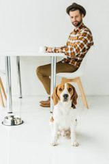 man drinking coffee, dog sitting on floor