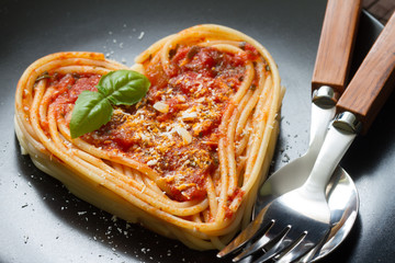 Spaghetti pasta heart love italian food diet abstract concept on black background
