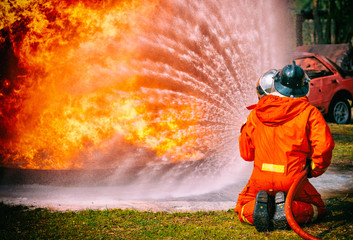 Firefighters water spray by high pressure nozzle in fire, Fire and rescue