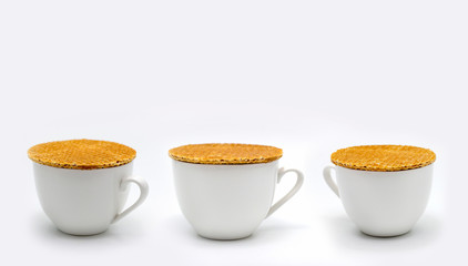 stroop waffles Dutch style streaming on ceramic cup on white background