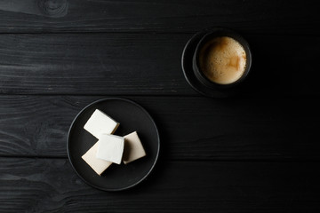 marshmallow in a black plate on black wood table