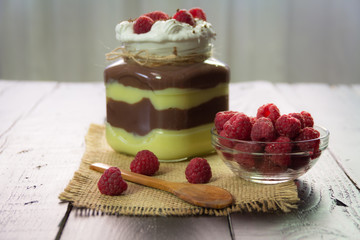 Tasty sweet pudding dessert. Raspberries and spoon on a wooden background