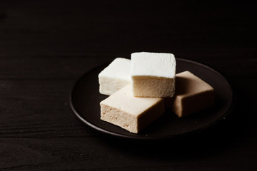 marshmallow in a black plate on black wood table