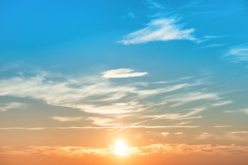 Sunset in the sky with blue orange clouds and big sun