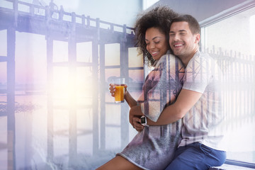 Absolute happiness. Delighted joyful positive man smiling and feeling happy while hugging his girlfriend