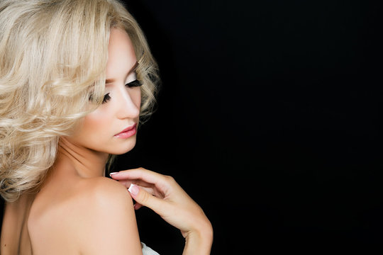 Beautiful blonde girl with professional make-up. Stylish curls, eyelashes and clean skin