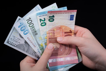 Hand holding American dollar  isolated on black background