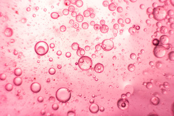 Pink oil bubbles on water surface