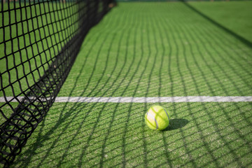 Paddle tennis court and net with a ball