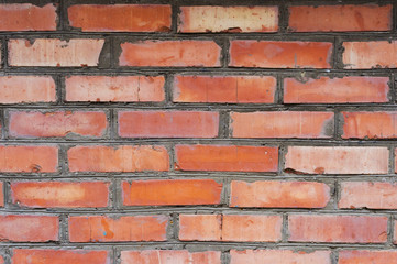 Fototapeta premium Textured background red brick wall with traces of old age and with different shades of bricks. Brick manual curve masonry and different color