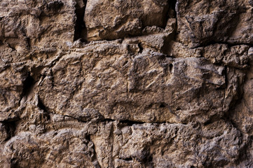 Close up Textured background of a wall of medieval stone masonry. The wall is sloppy built of mountain stones. Medieval style