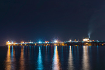 Fototapeta na wymiar Night view over petroleum power plant sea front, industrial background