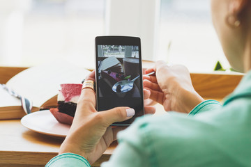Woman with a cup of cappuccino and a piece of dessert on the spoon