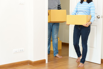 Fototapeta na wymiar Couple holding boxes into their home - moving house concept
