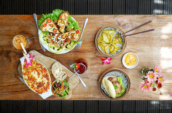 Raclette Tartiflette And Salad Chevre Chaud - French Kitchen.  Bao Burger And Asparagus Tofu Dumpling - Chinese Kitchen. Top View In Cafe.