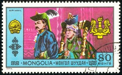 Ukraine - circa 2018: A postage stamp printed in Mongolia show A man and a woman in a traditional Mongolian bright, colorful suit. Series: National Achievements. Circa 1972.