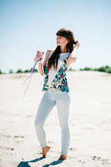 Beautiful stylish sexy young girl with a glass of wine, champagne in sand, beach in the nature. Style boho. Party. Maiden evening Hen-parties. Bachelorette. Close up. Portrait of a girl on the sand.