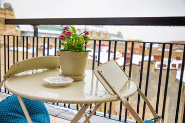 Flower pot on table on home balcony with cityscape view