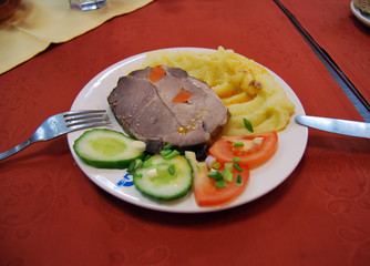 A good lunch in the dining room at the factory:  mashed potatoes, sliced vegetables and baked meat 