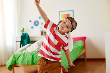 happy little boy in pilot hat playing at home © Syda Productions