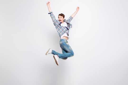 Mid-air shot of mad, crazy, cheerful, successful guy in casual outfit with bristle jumping with open mouth, hands up, triumphant, gesturing against white background