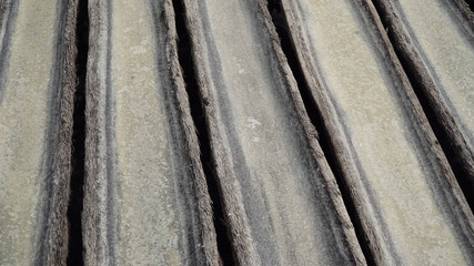 Production of sea salt in the Bali,Indonesia. Salt crystallizes out of the ground in salt farm, filled with natural salt from the sea.