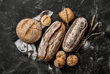 Gordijnen Bakery - rustic crusty loaves of bread and buns on black © pinkyone