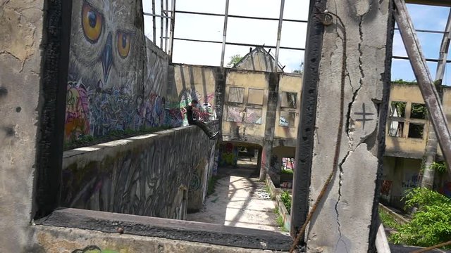 Man takes photos of abandoned roofless building on a sunny day