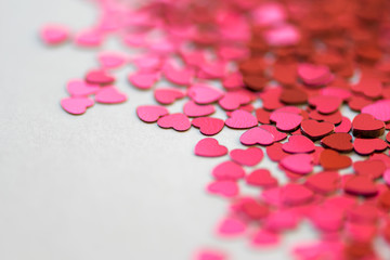 Red and pink glitter hearts on white background. Selective focus. Valentine´s Day.