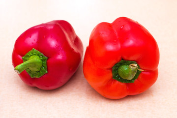 Two red sweet peppers with drops of water. Fresh vegetables for a healthy diet