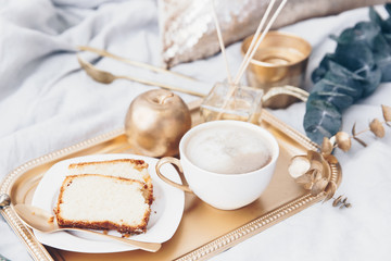 Morning breakfast with coffee in bed. Moody composition with gold decoration